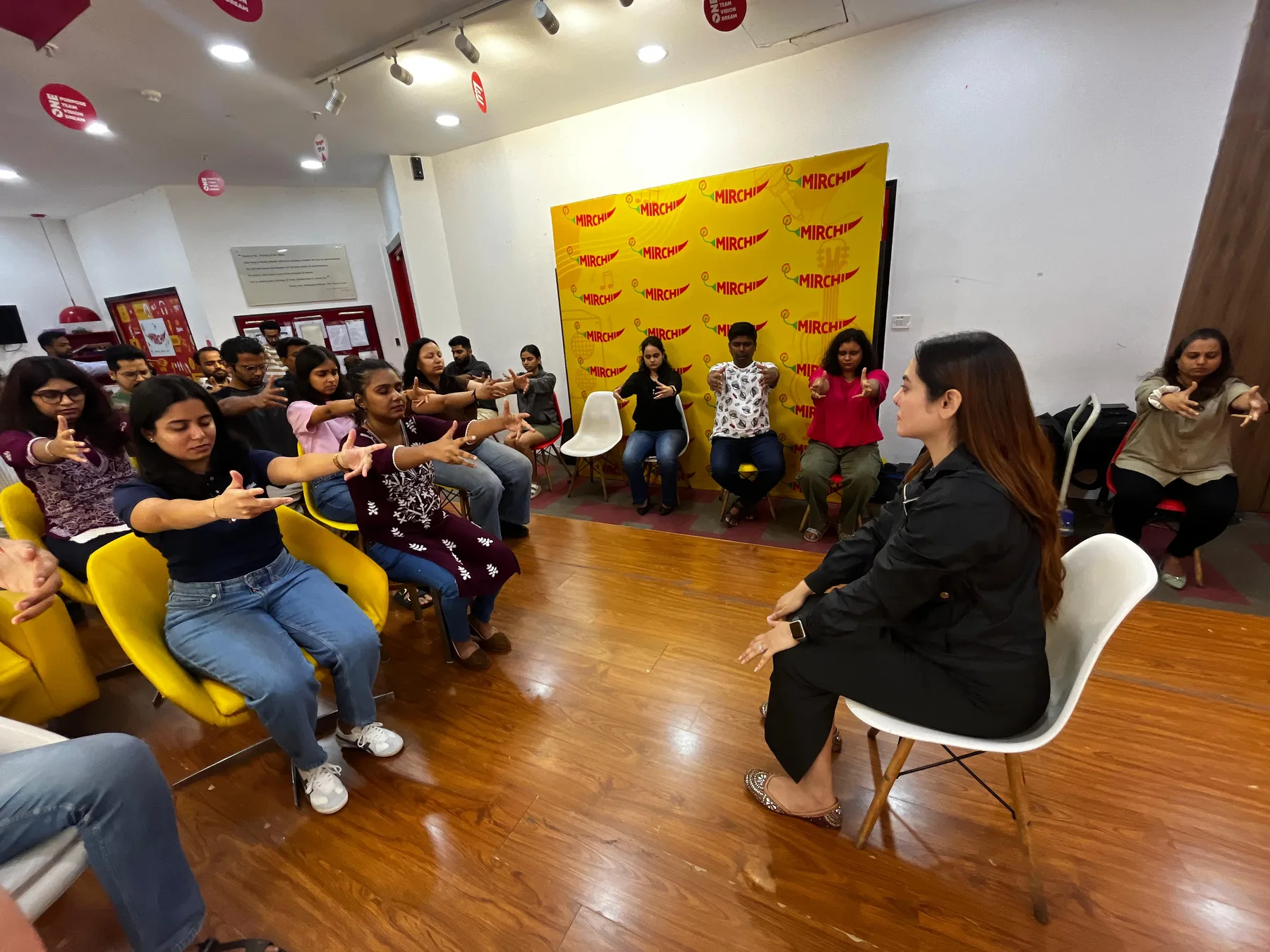 Vibha Jain conducting a group hypnotherapy session with participants seated in a circle following a guided exercise.
