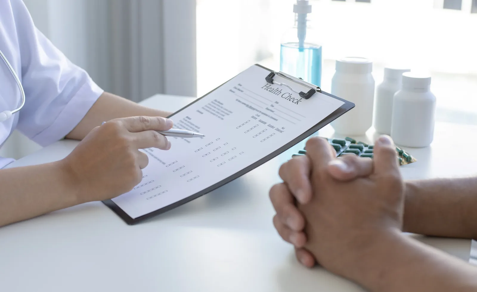 A healthcare professional completing a health check form during a consultation.